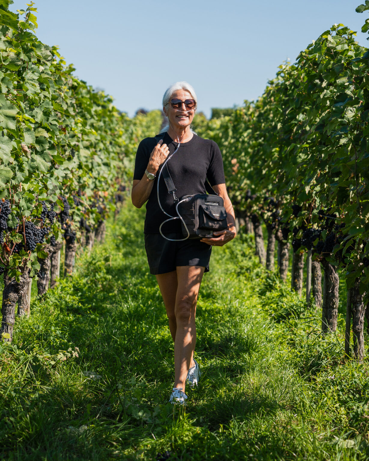 Korisnica hoda vinogradom s DeVilbiss iGo2 u torbi preko ramena